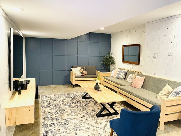 A modern living room with a sofa, a coffee table, and a blue chair.