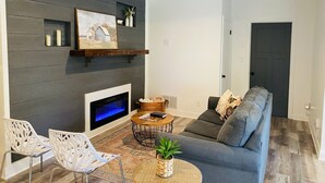 Een moderne woonkamer met een open haard, een bank en een salontafel.