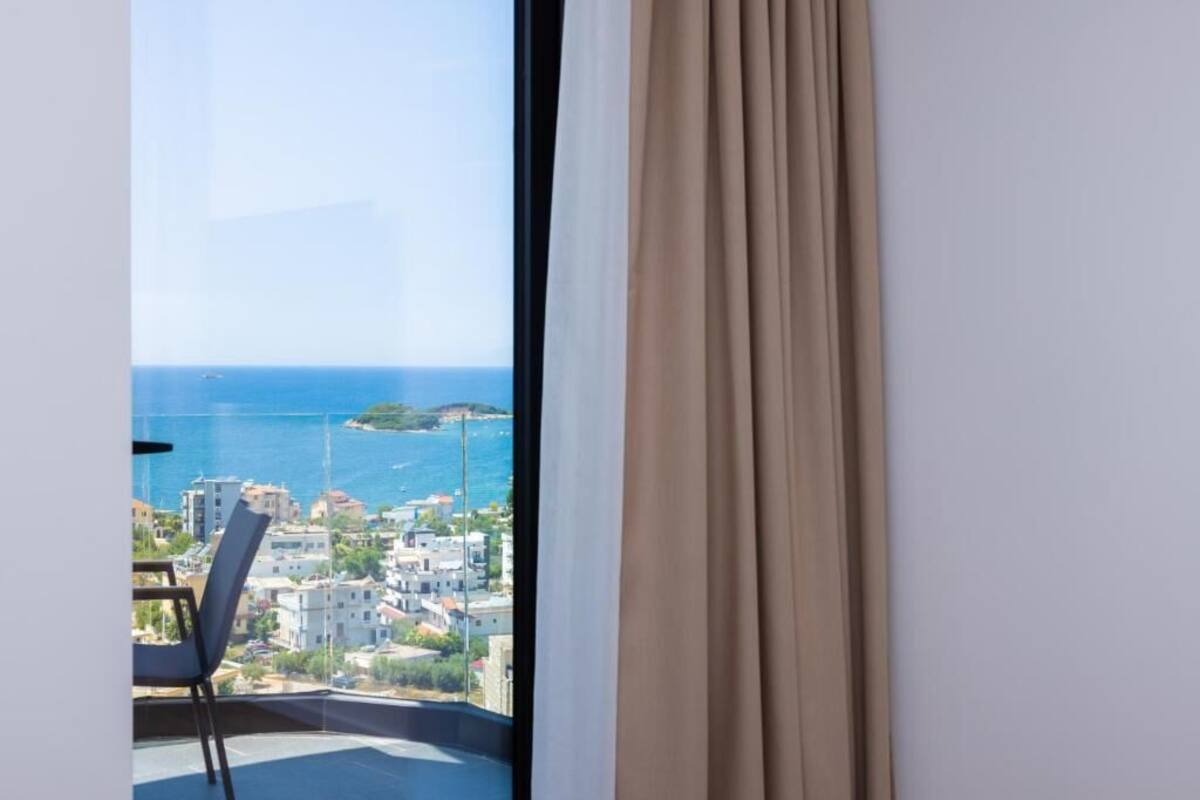 A balcony with a view of the sea and buildings.