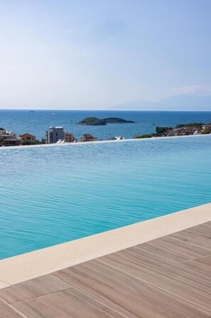 A swimming pool with a view of the sea and buildings in the background. - Lans Hotel (Ksamil)