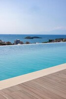 Una piscina al aire libre de temporada, sombrillas, tumbonas