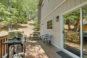 Une terrasse avec un barbecue, des chaises et une table.