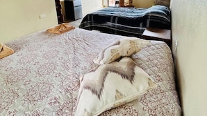 A bedroom with two beds, a desk, and a window. - Ocean View (Monteverde)