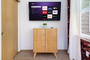 Ein an der Wand befestigter Fernseher, der verschiedene Streaming-Dienste anzeigt.