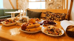 A dining table with various dishes, a wooden bench, and a patterned wall. - Silkroad Guest house (Bishkek)