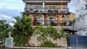 Un immeuble de deux étages avec un balcon au dernier étage.