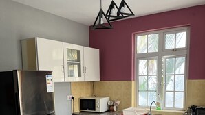 Une cuisine moderne équipée d’un réfrigérateur en acier inoxydable, d’un four à micro-ondes, d’un évier et d’une cuisinière à gaz.