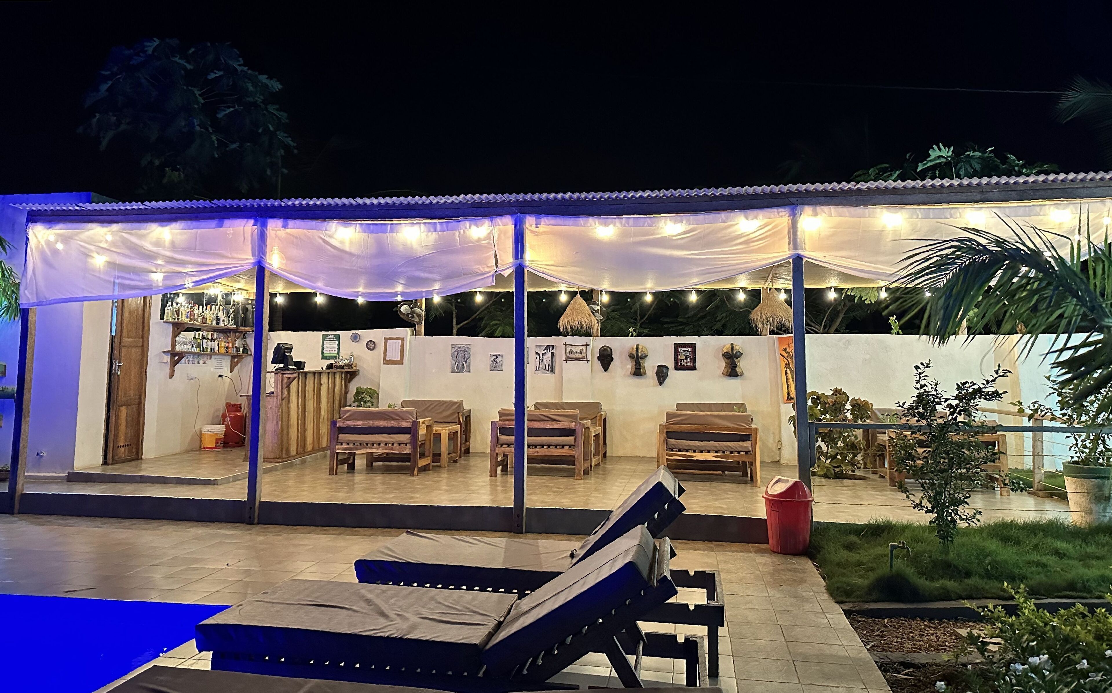 Un espacio al aire libre con mobiliario de madera y una barra.