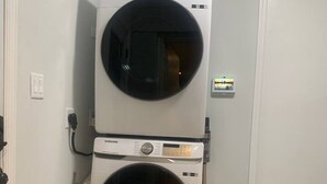 A laundry room with two stacked front-loading washing machines. - Silver Spring Tranquil Bliss-2BR/1BA Nature/Access (Silver Spring)