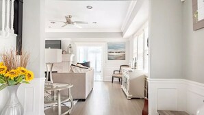 A spacious hallway with a ceiling fan, a sofa, a glass table, and a cabinet. - LUXURY 6000 sqft Mansion Downtown Orlando 6BR/5BA SLEEPS 14  Arcade Rooftop Deck (Orlando)