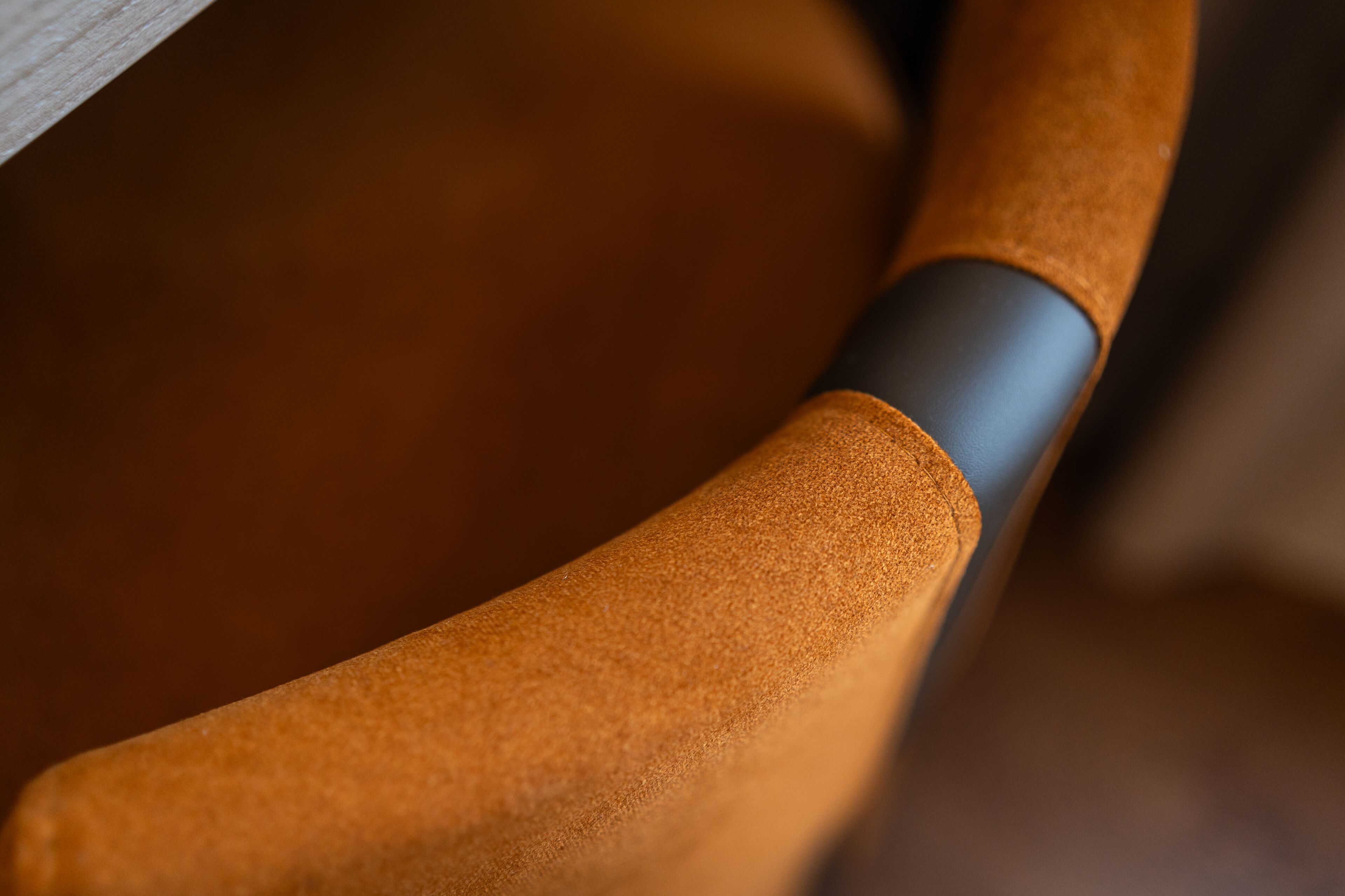 A close-up of a chair's armrest and backrest, highlighting the texture and material.