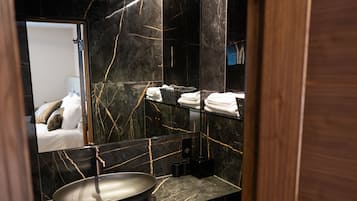 Een douche, designer toiletartikelen, een haardroger, handdoeken