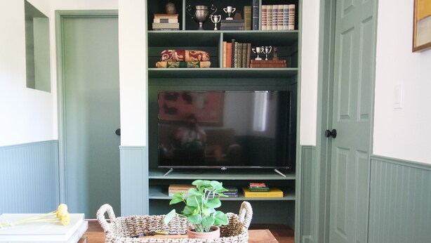 A living room with a television, a bookshelf, and a woven basket with a plant. - Perfectly located with 2 bike cruisers available to help you explore the town! (Prescott)