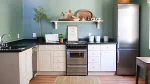 A kitchen with white cabinets, a stainless steel stove, and a refrigerator. - Perfectly located with 2 bike cruisers available to help you explore the town! (Prescott)