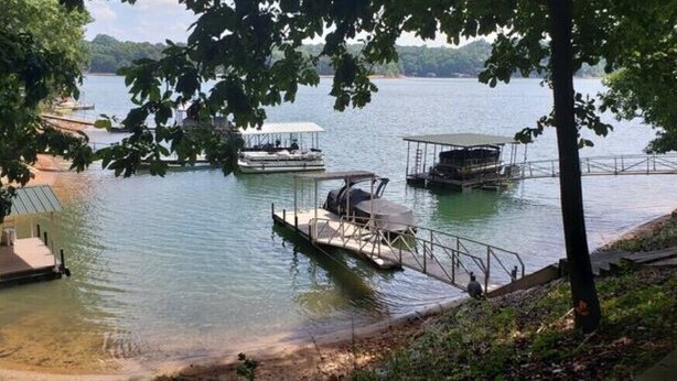 Un muelle a orillas del lago con barcos y una zona cubierta.