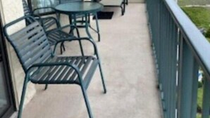 A balcony with a table and chairs, a view of the ocean, and a railing. - 3BR 3BA Oceanfront 7th Floor N. Myrtle Beach Condo (North Myrtle Beach)