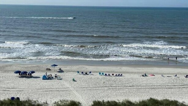 A beach with umbrellas, sun loungers, and people. - 3BR 3BA Oceanfront 7th Floor N. Myrtle Beach Condo (North Myrtle Beach)