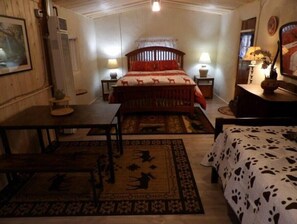 Cozy bedroom with a traditional design, featuring a wooden bed, bedside tables, and framed artwork.