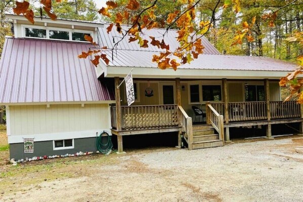 A two-story building with a covered porch and a small window.