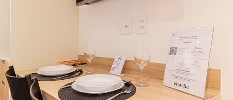A dining table set with plates, cutlery, and wine glasses, a menu, and a sign indicating no smoking.