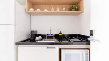 Uma cozinha moderna com micro-ondas embutido, fogão e pia.