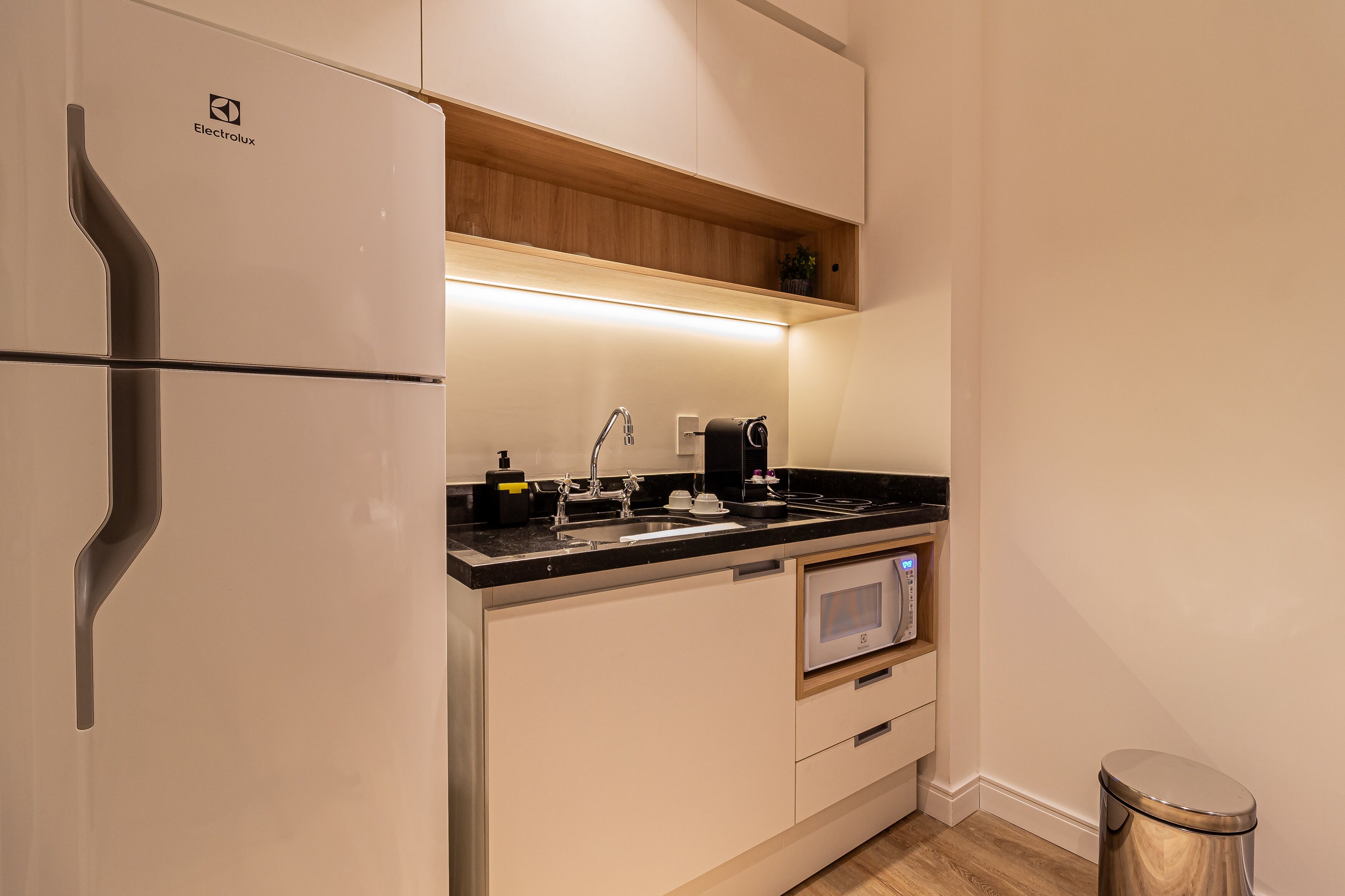A modern kitchen with a built-in refrigerator, a microwave, and a sink.
