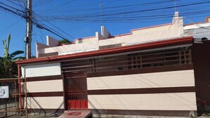 Un edificio con un cancello rosso e una rampa che conduce all'ingresso.