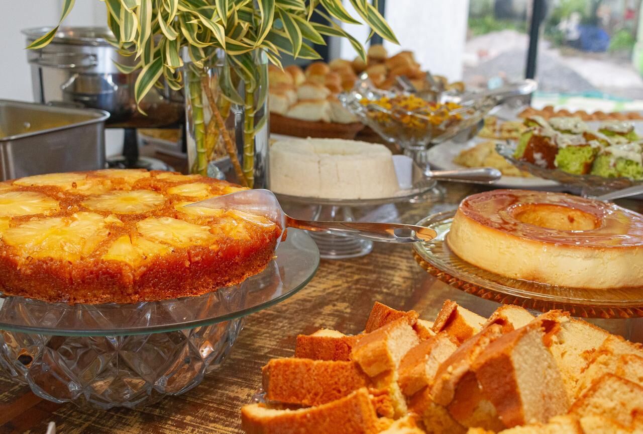 Un buffet con diversi dolci tra cui una torta rovesciata all'ananas, uno cheesecake e altre prelibatezze.