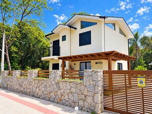 Et toetagers hus med en stenvæg og en træport.