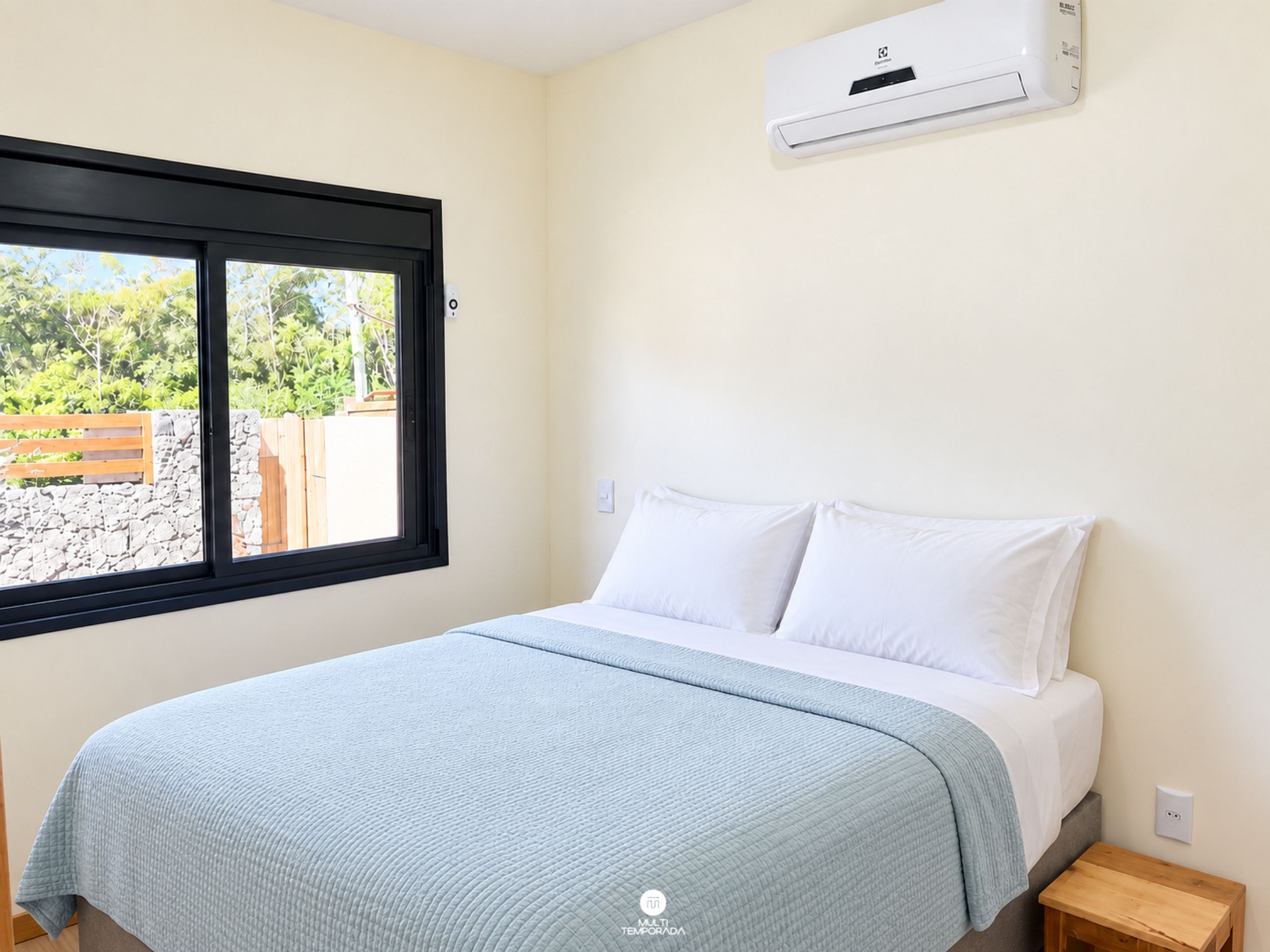 Un dormitorio con una cama, ventana y equipo de aire acondicionado.