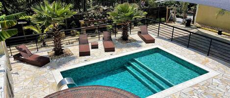 Een buitenzwembad, parasols voor strand/zwembad