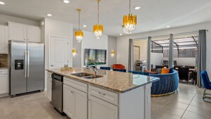 A modern kitchen with a built-in island, stainless steel appliances, and pendant lighting. - Escape to a Themed Bedroom Retreat with PS5, Private Pool & BBQ (DAVENPORT)