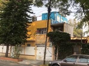 A two-story building with a yellow facade and a blue upper section. - El Caracol bonito estudio cocina y baño privados (Ciudad de México)