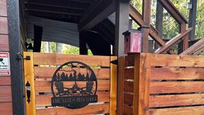 A wooden gate with a logo and text indicating 'The Nest @ Pine Lodge' and 'EST 2023'.