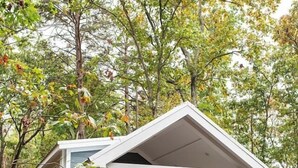 A small, single-story house with a covered porch and a wooden staircase leading to the entrance. - Tiny Home | Grill, Near East Fork (Mentone)