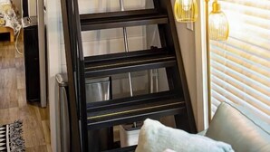 A modern interior with a black staircase, a wooden ceiling, and a window with blinds. - Tiny Home | Grill, Near East Fork (Mentone)