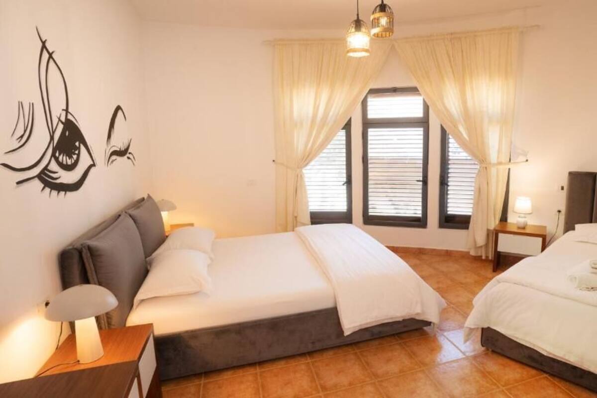 A bedroom with a bed, bedside tables, and a wall decoration.