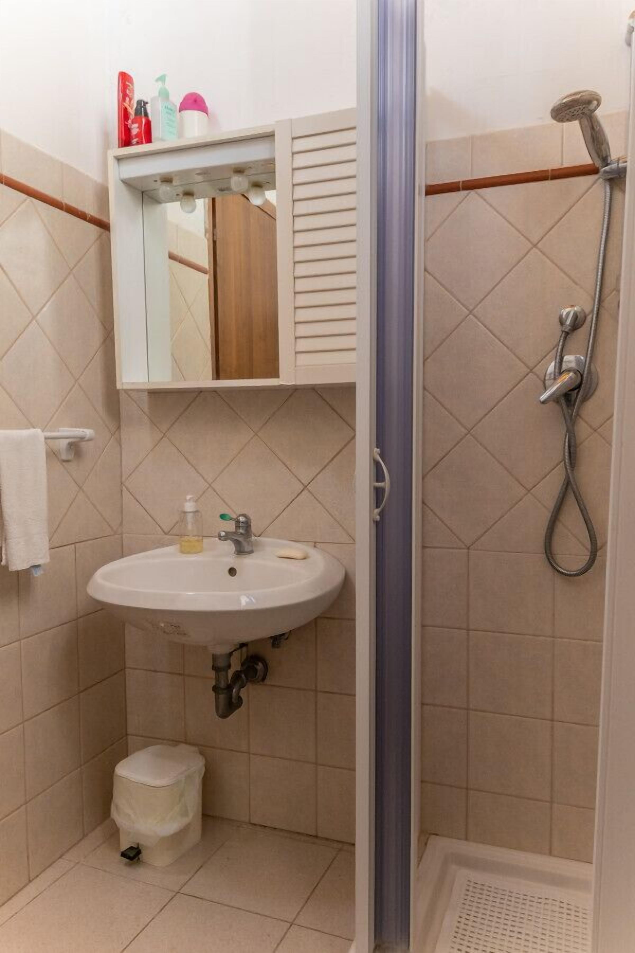 Un bagno con lavandino, specchio e doccia.
