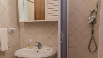 Un bagno con lavandino, specchio e doccia.