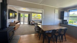 A modern kitchen with a wooden table and chairs, a built-in stove, and a large window. - Twizel Tranquility, FREE Wi-Fi (Twizel)