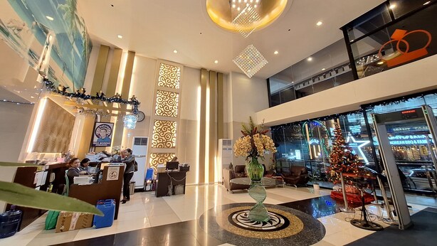 A spacious lobby with a reception desk, decorative lighting, and a large mural on the wall. - Manila Bayview Rental Luxury 3BR 3BA Condo w/Balcony Sunset View Pool Kitchen (Manila)