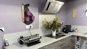 A kitchen with a modern design, featuring a wooden cabinet, a built-in stove, and a wall-mounted range hood.