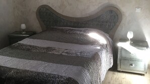 A bedroom with a bed, two bedside tables, and a nightstand.
