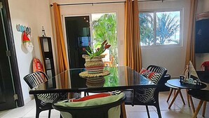 A dining area with a glass table, black chairs, and a decorative centerpiece. - Spectacular beachfront apartment, Spacious terrace with an unparalleled view. (Palo Grande)