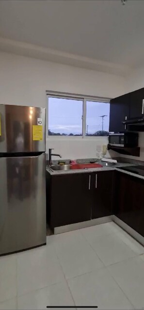 Fridge, microwave, coffee/tea maker, cookware/dishes/utensils