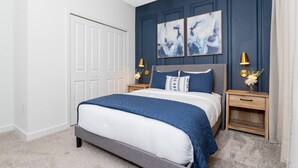 A bedroom with a bed, two nightstands, a chandelier, and artwork on the wall. - 2994 - Great Family Home near Disney, private pool, Storey Lake Resort (Kissimmee)