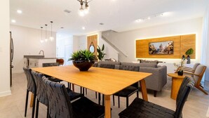 A modern kitchen with a wooden dining table, black chairs, and a central plant. - 2994 - Great Family Home near Disney, private pool, Storey Lake Resort (Kissimmee)