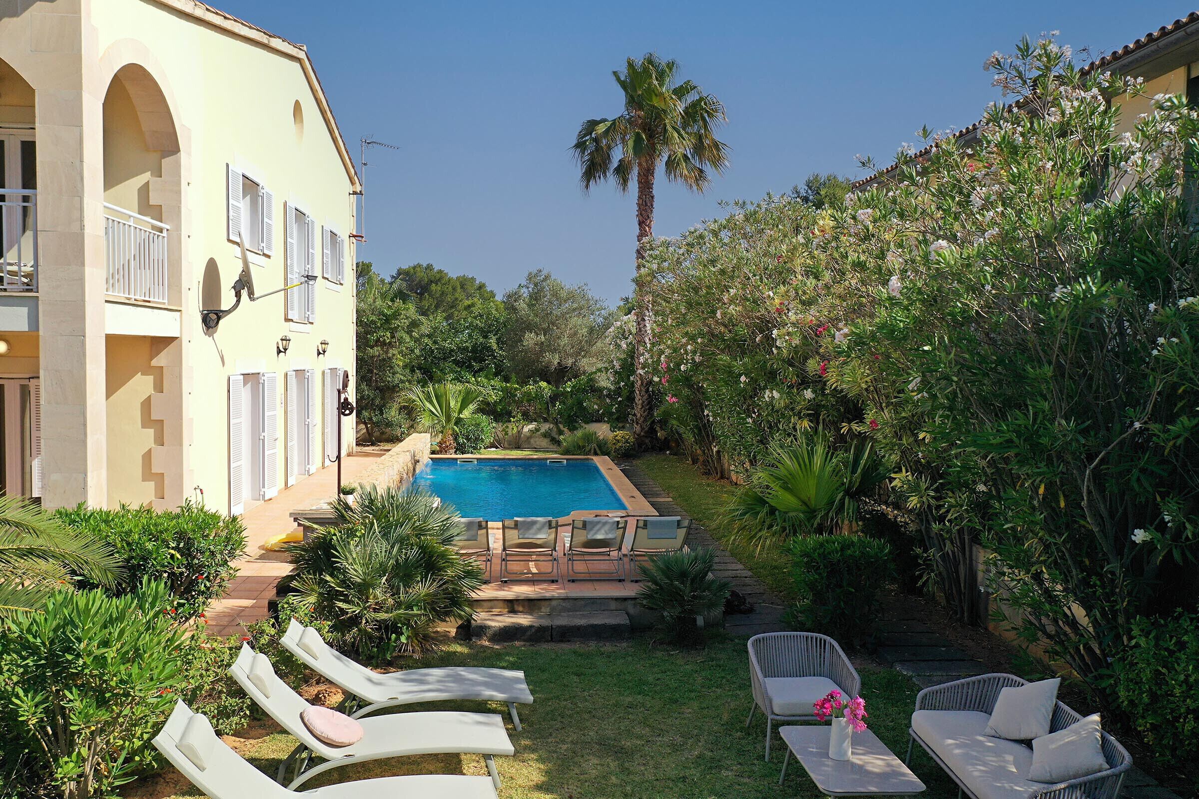 Area piscina con sedie a sdraio e un piccolo giardino.