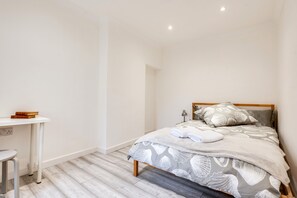 A bedroom with a bed, a desk, and a chair. - Bright & Spacious 2-Bedroom House (Oxford)