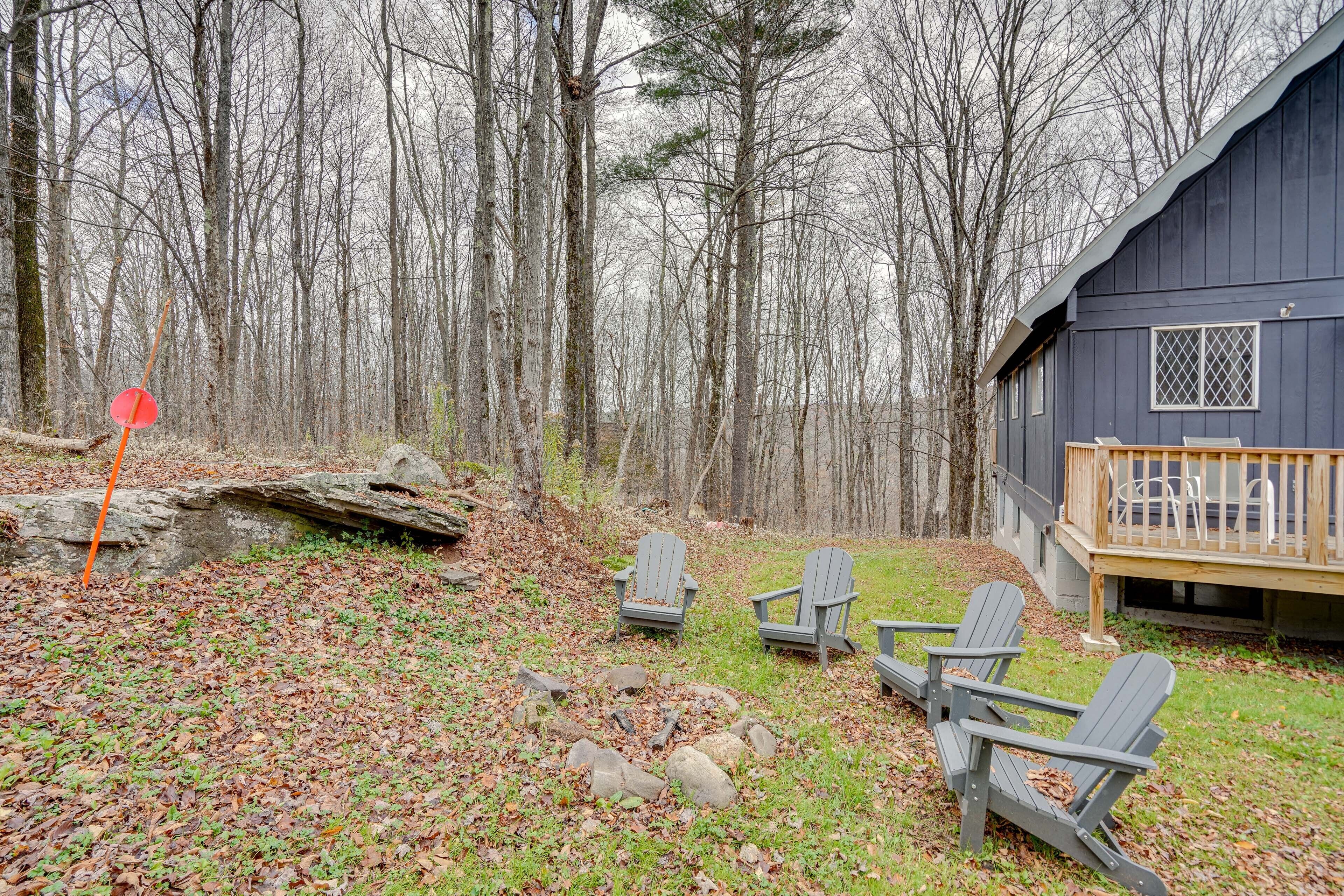 Una baita con veranda, immersa in una foresta. Sono presenti sedie Adirondack e un braciere.